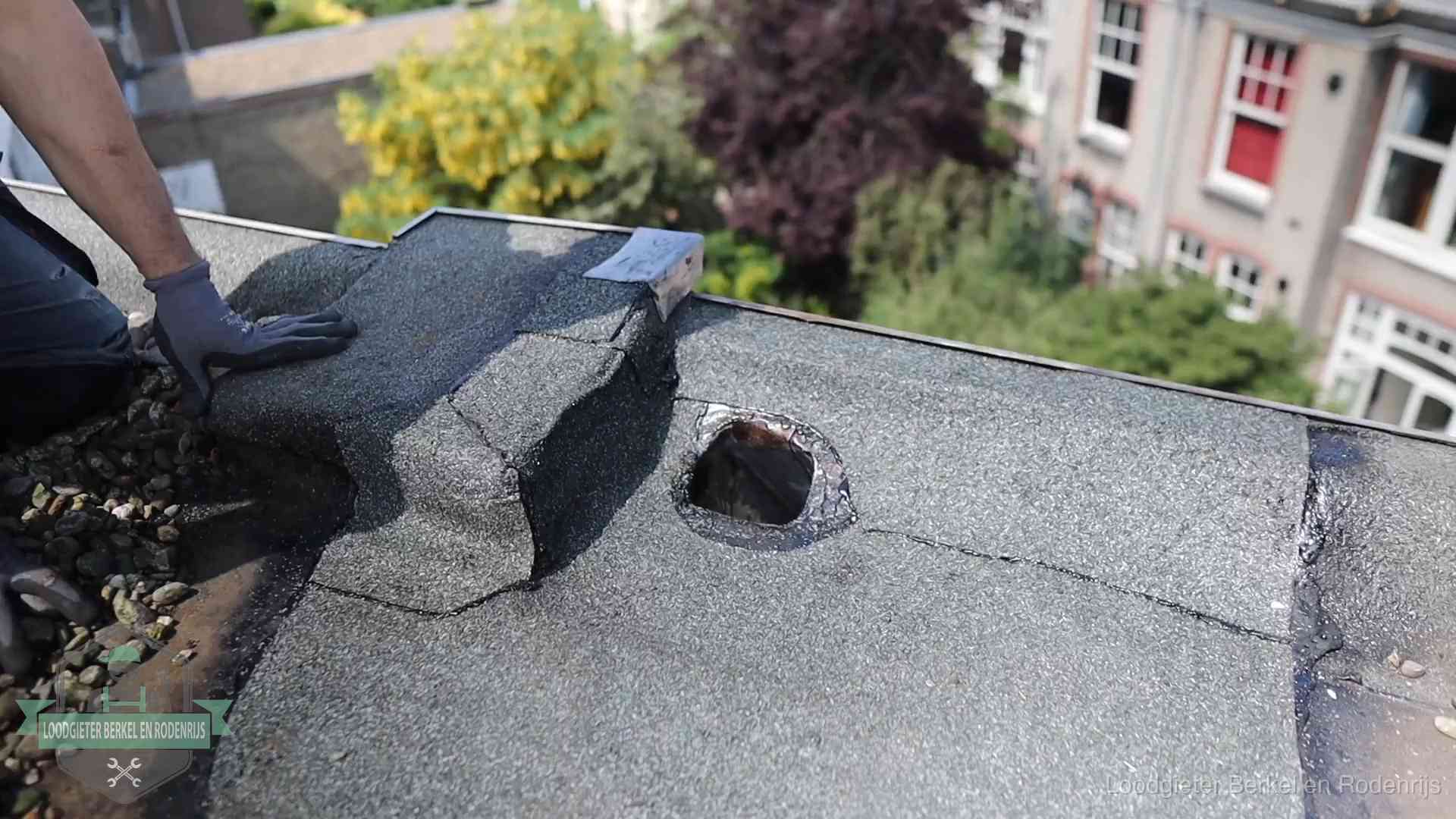 Loodgieter inspecteert een beschadigd bitumen plat dak tijdens een daklekkage-inspectie in Berkel en Rodenrijs