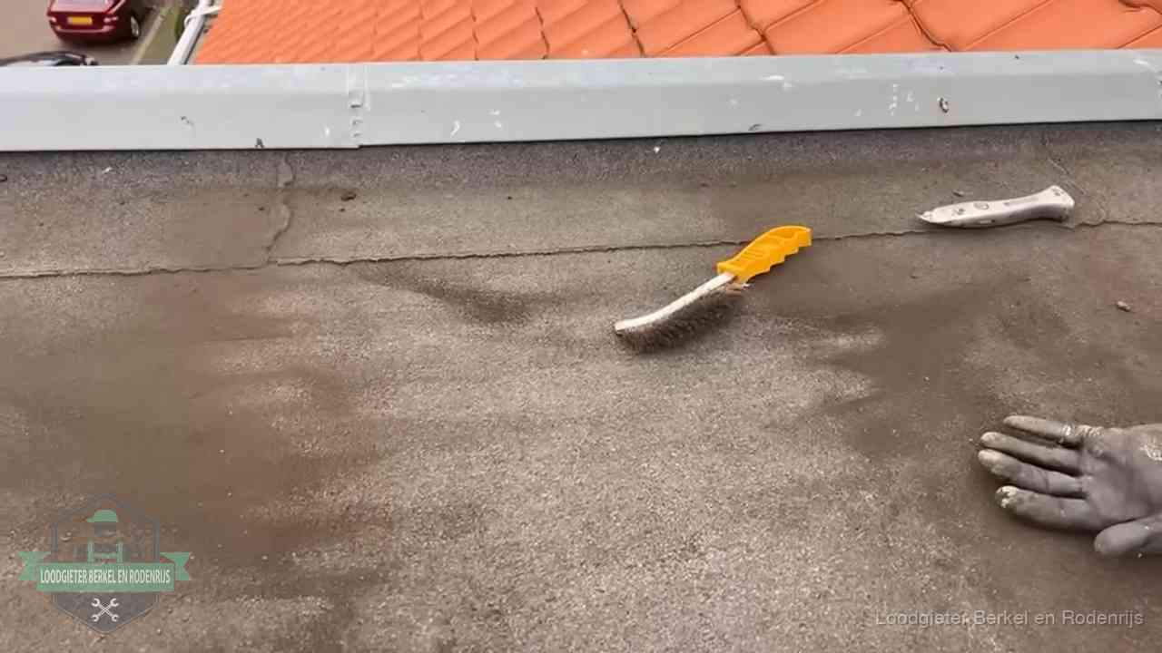 Dakdekker bereidt een bitumen plat dak voor op reparatie bij de daktrim in Berkel en Rodenrijs