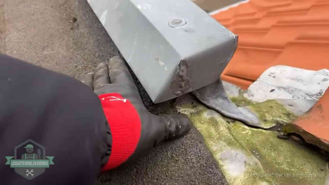Controle van een zinken hemelwaterafvoer met loodslab bij dakpannen in Berkel en Rodenrijs