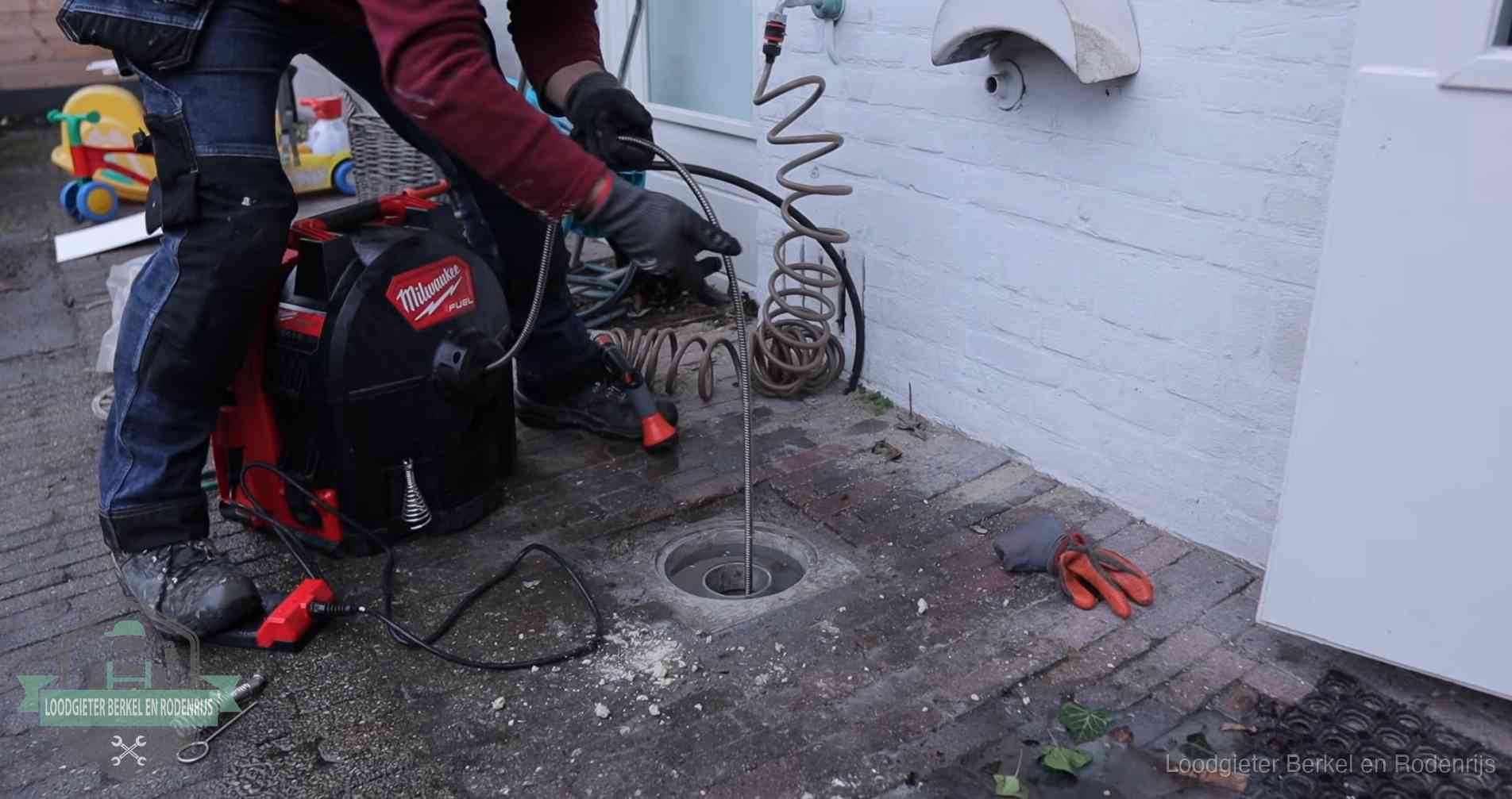Ontstoppingsputje in de bestrating naast de gevel van een woning in Berkel en Rodenrijs