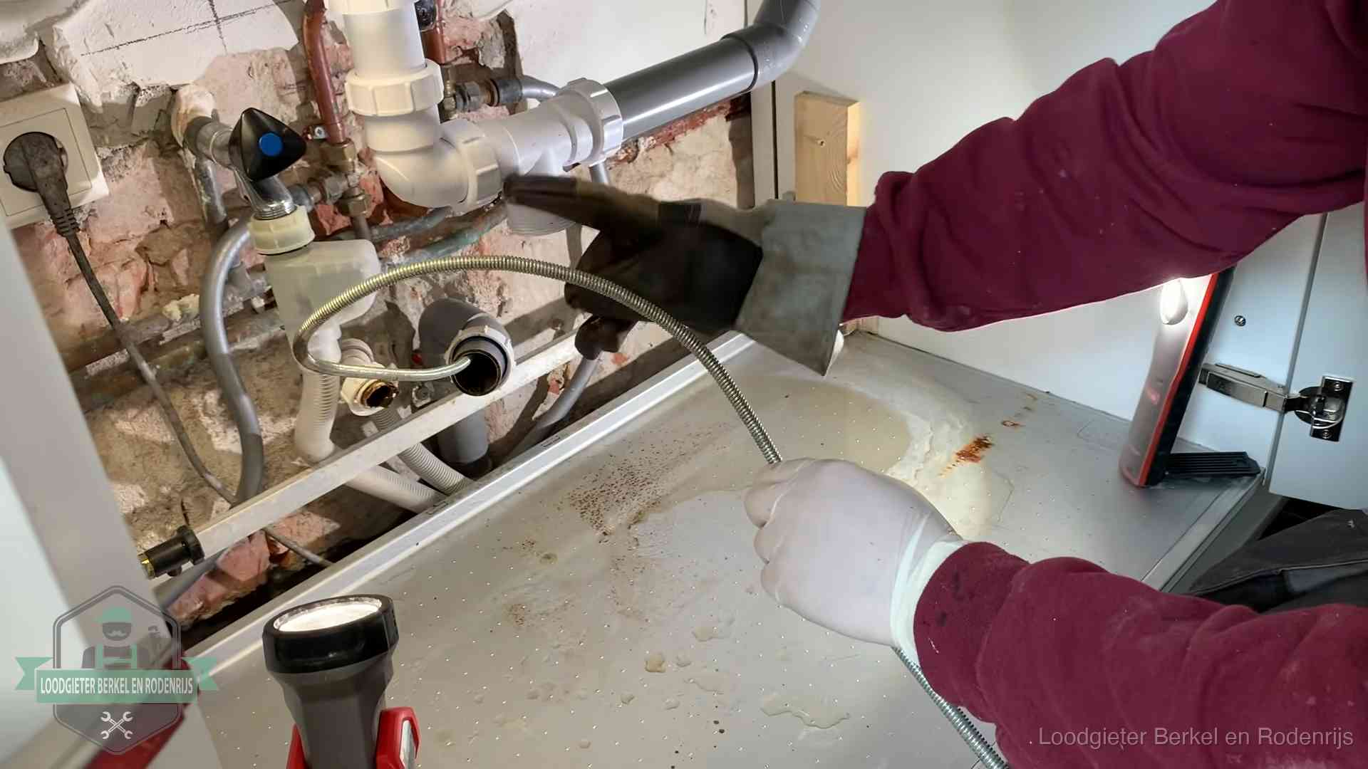 Ontstoppingsveer gaat in een geopende sifonaansluiting onder het aanrecht in Berkel en Rodenrijs