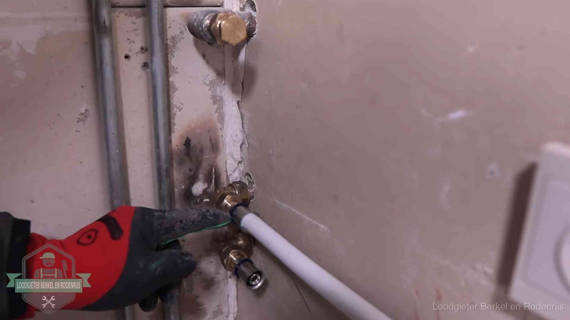 Garantie op loodgieterswerk in Berkel en Rodenrijs Loodgieter wijst de persfitting op nieuwe muuraansluitingen aan in een woning in Berkel en Rodenrijs