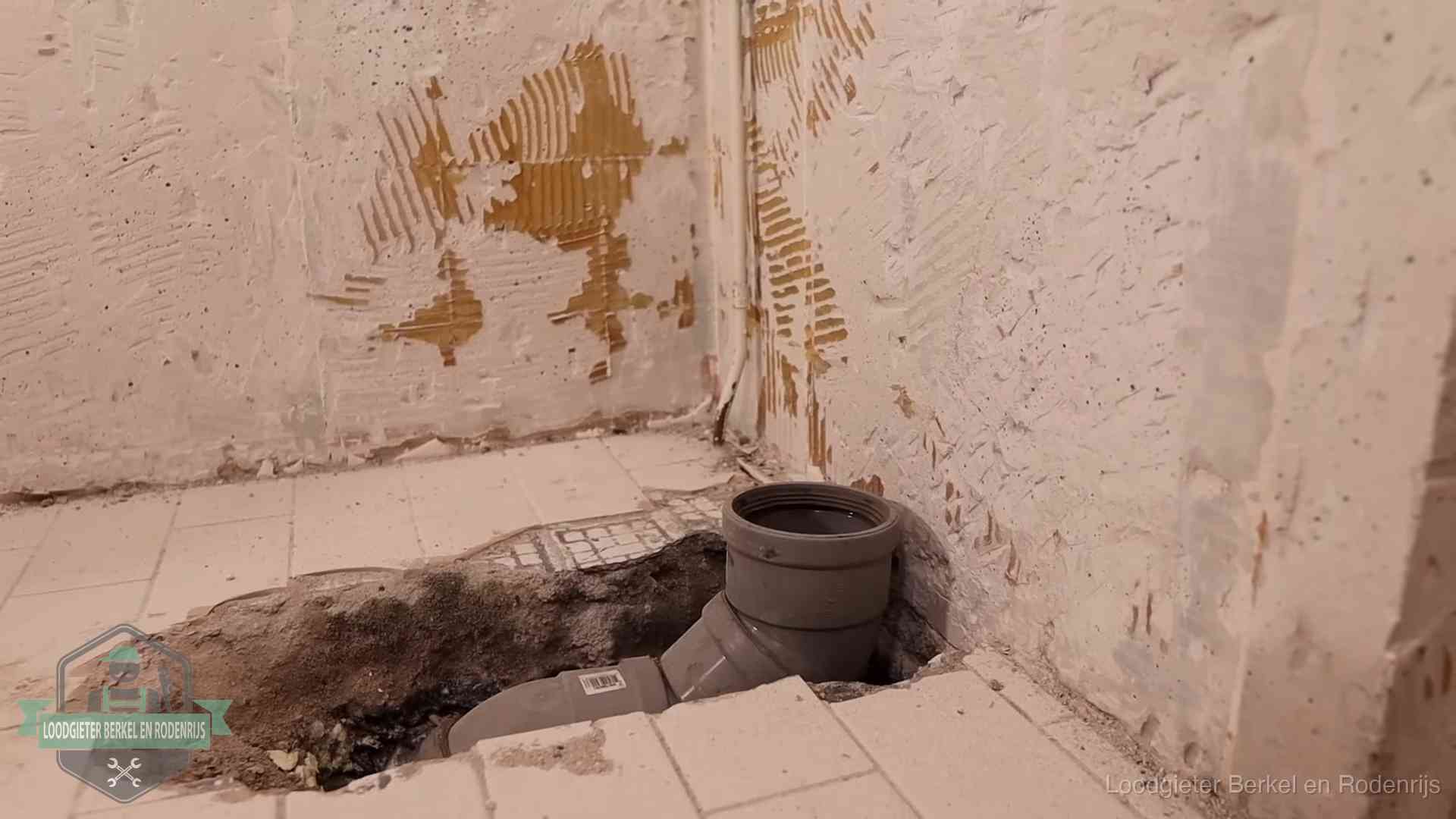 Opengebroken vloer met een nieuwe pvc-rioolbocht in een gegraven sleuf in Berkel en Rodenrijs
