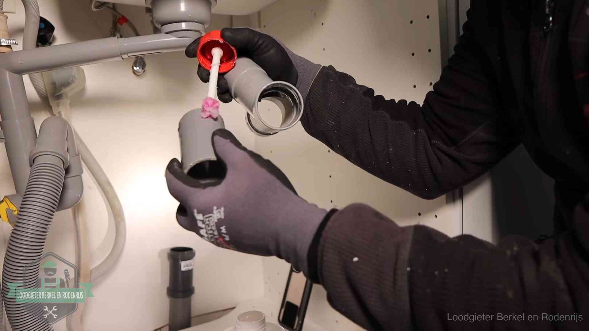 Loodgieter demonteert en reinigt de sifon onder een keukenkast in Berkel en Rodenrijs
